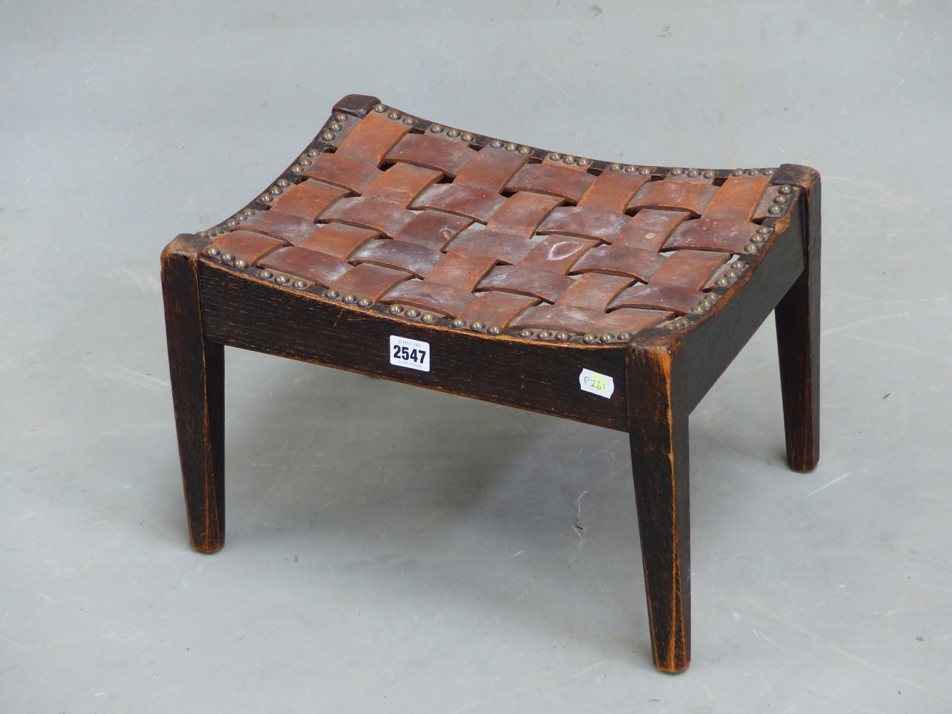 A SIMPSON OF KENDAL OAK STOOL WITH INTERWOVEN LEATHER STRAP WORK SEAT. W 40 x D 30.5 x H 25.5cms.