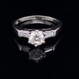 A PLATINUM AND DIAMOND TRILOGY RING. THE CENTRAL DIAMOND APPROX. ESTIMATED WEIGHT 0.70cts, I/SI2/3