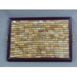 A TWO HANDLED TRAY GLAZED OVER WINE BOTTLE CORKS, THE BROWN PAINTED WOOD FRAME. 63.5 x 44cms.
