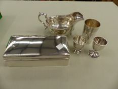 A HALLMARKED SILVER GRAVY BOAT, A SILVER CIGARETTE BOX, A SILVER BEAKER, AND TWO SILVER EGG CUPS.