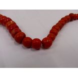 A STRING OF VINTAGE GRADUATED CORAL BEADS, CARVED CORAL EAR CLIPS, AND TWO COSTUME BRACELET.