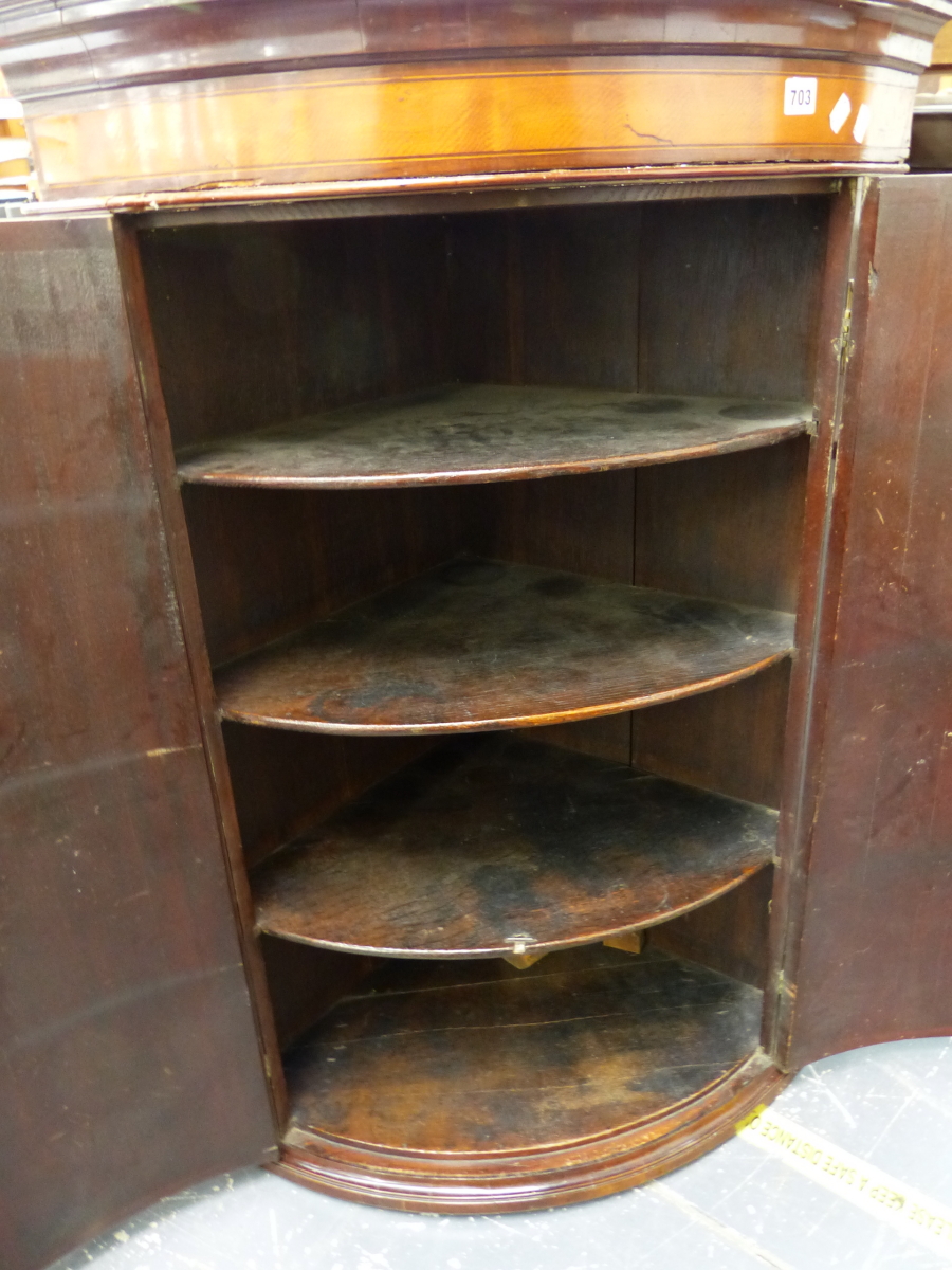 A GEORGE III MAHOGANY BOW FRONT CORNER CABINET.