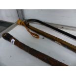 AN ORIENTAL CARVED BAMBOO WALKING STICK AND TWO OTHERS.