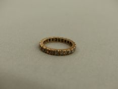 A 9ct GOLD SPINEL SET ETERNITY RING.