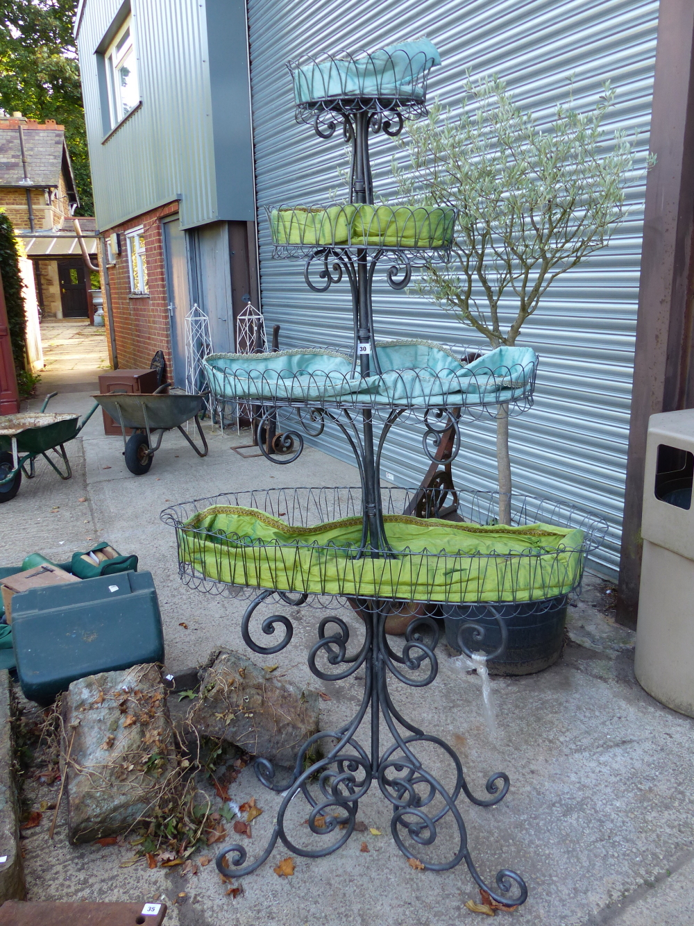 A LARGE FOUR TIER WROUGHT IRON PLANT STAND.