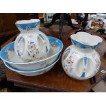A PAIR OF LATE VICTORIAN ART AND CRAFTS WASH JUG AND BASIN SETS.
