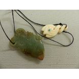 AN ANTIQUE CARVED JADE FISH FORM PENDANT, TOGETHER WITH A LATER SOUTH SEA PENDANT.