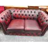 A LEATHER UPHOLSTERED BUTTON BACK CHESTERFIELD SETTEE.