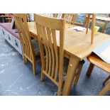 AN OAK EXTENDING TABLE AND CHAIRS.