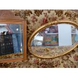 A GILT FRAMED OVAL WALL MIRROR AND A SATINWOOD MIRROR.