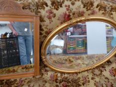 A GILT FRAMED OVAL WALL MIRROR AND A SATINWOOD MIRROR.