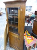 A HAND MADE OAK CORNER CABINET.