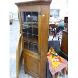 A HAND MADE OAK CORNER CABINET.