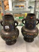 A PAIR OF ANTIQUE CLOISONNE BRONZED VASES WITH STYLISED HANDLES.