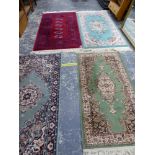 A CHINESE WOOL RUG AND FOUR MACHINE MADE RUGS.