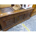 AN ANTIQUE CARVED OAK PANEL COFFER.