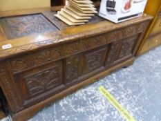 AN ANTIQUE CARVED OAK PANEL COFFER.