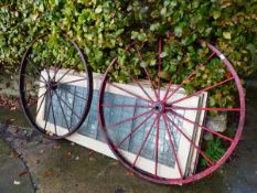 A PAIR OF VINTAGE CAST IRON WAGON WHEELS.