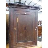 A GEORGIAN OAK CORNER CABINET.