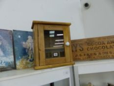 A SMALL PINE GLAZED DOOR CABINET AND THREE SIGNS.