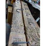 TWO CARVED FAR EASTERN HARD WOOD PANELS FITTED AS COAT HOOKS