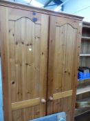 A PAIR OF PINE TWO DOOR WARDROBES.