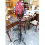 AN UNUSUAL WROUGHT IRON STANDARD LAMP WITH CRANBERRY SHADE.
