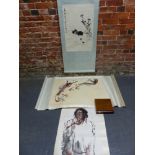 THREE CHINESE SCROLLS, ONE PRINTED IN BLACK WITH A CAT CROUCHING BY FLOWERS. 67 x 43cms. THE