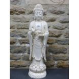A BLANC DE CHINE FIGURE OF THE BUDDHA STANDING ON A DOUBLE LOTUS PLINTH, HIS RIGHT HAND RAISED IN