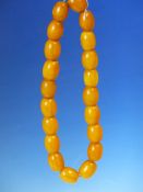 A CONTINUOUS STRING OF 20 UNIFORM ETHIOPIAN AMBER BEADS PROBABLY FIRST HALF OF THE 20th C. MEASURING