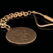 AN 18ct GOLD UNHALLMARKED KEYRING. THE ROUND DISC WITH AN ENGRAVED INITIAL S, COMPLETE WITH 18ct