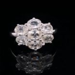 A 9ct WHITE GOLD OVAL CUT WHITE GEMSTONE CLUSTER RING, FINGER SIZE O, WEIGHT 3.7grms.