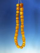A STRING OF 28 ETHIOPIAN AMBER BEADS,PROBABLY FIRST HALF OF THE 20th C. VARYING IN SHAPE AND SIZE.