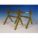 A PAIR OF CHRISTOPHER DRESSER DESIGN BRASS FIRE IRON RESTS, THE INVERTED Y SHAPED ENDS EACH JOINED