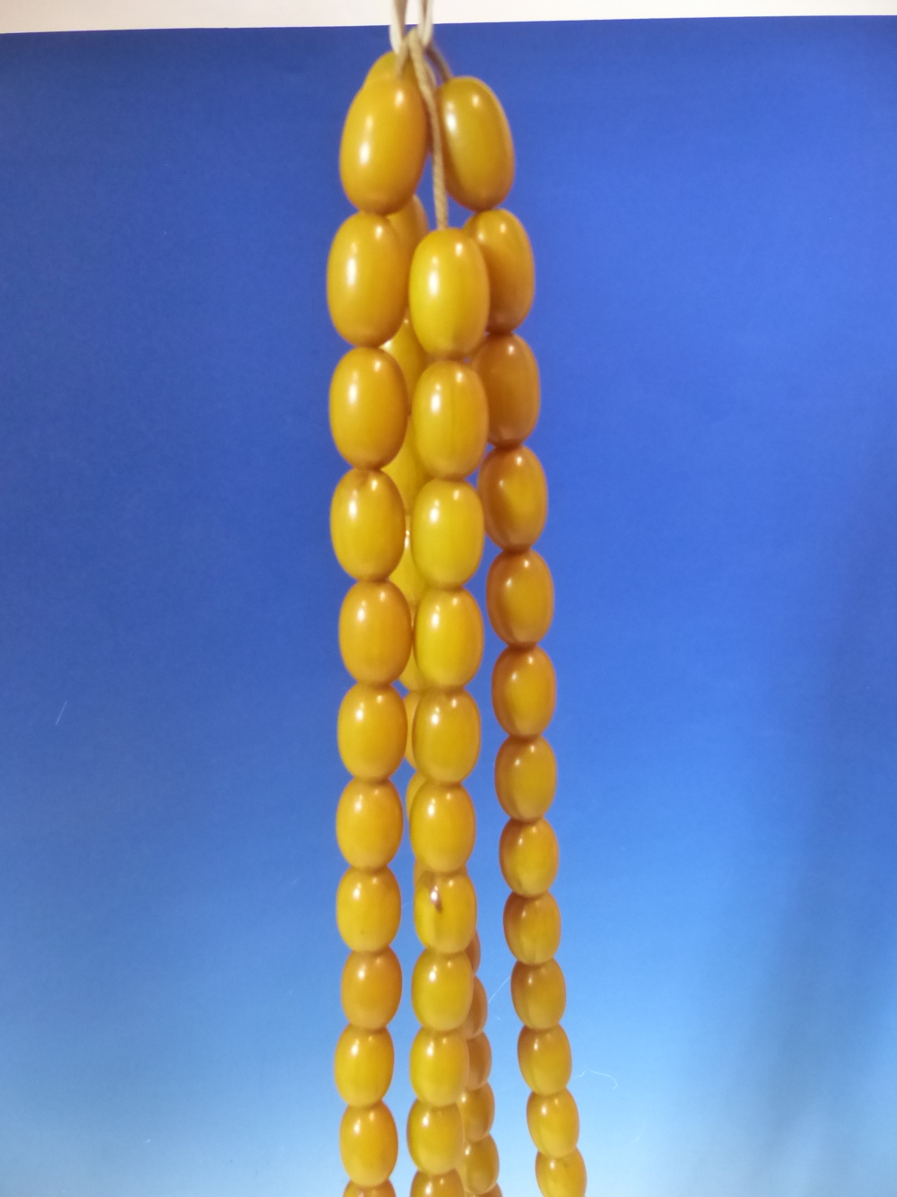 A CONTINUOUS STRING OF 80 UNIFORM OVAL ETHIOPIAN AMBER BEADS WITH KNOT TASSEL PROBABLY FIRST HALF OF - Image 2 of 7