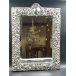 AN ANTIQUE VICTORIAN HALLMARKED SILVER FRONTED EASEL BACKED MIRROR WITH A CHASED AND PIERCED