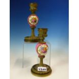 A PAIR OF BRONZE AND PORCELAIN CANDLESTICKS, THE ROSE POMPADOUR GROUND KNOPS EACH PAINTED WITH TWO