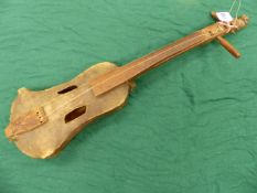 A VINTAGE TRIBAL MADE STRINGED MUSICAL INSTRUMENT , THE BODY OF STRETCHED AND SEWN HIDE WITH CRUDELY