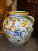 AN ITALIAN MAJOLICA TWO HANDLED WET DRUG JAR LABELLED MESIMUS AMONGST COLOURED FRUIT AND FLOWERS.