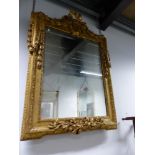A 19th C. RECTANGULAR MIRROR WITHIN A GILT FRAME WITH RIBBON TIED ESCUTCHEON AT THE CREST AND HUNG