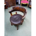 A VICTORIAN DESK CHAIR THE TUB BACK UPHOLSTERED IN LEATHER WITH A GRIFFIN SUPPORTED ARMORIAL ABOVE