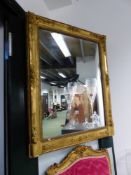 A FRENCH 19th.C. RECTANGULAR MIRROR WITHIN A GILT FRAME CARVED WITH FLOWERS AT THE CORNERS AND