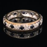 A 9ct GOLD SAPPHIRE AND DIAMOND FULL ETERNITY RING, FINGER SIZE T. WEIGHT 4.6grms.