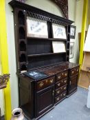 A GEORGIAN AND LATER OAK DRESSER, THE ENCLOSED BACK WITH THREE SHELVES FLANKED BY FIVE ROUND ARCH