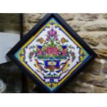 A FRAME OF FOUR PERSIAN TILES PAINTED WITH TWO BIRDS FLANKING A VASE OF FLOWERS WITHIN A BLUE,