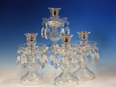 A SET OF FOUR CLEAR GLASS LUSTRE CANDLESTICKS. H 20cms.