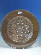 AN ARTS AND CRAFTS COPPER DISH WORKED WITH A CENTRAL TUDOR ROSE, THE BACK WITH A SUSPENSION LOOP.