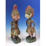 A PAIR OF BURMESE BRIGHTLY PAINTED CARVED WOOD FIGURES OF A HIRSUTE PINK FACED MAN STANDING WITH HIS