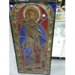 A VICTORIAN STAINED GLASS PANEL OF A SAINT STANDING IN A ROUND ARCHED NICHE, THE LEADED GLASS