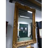 A RECTANGULAR MIRROR IN A GILT FRAME WITH ROCAILLE SHELL CORNERS AND CENTRES TO A DIAMOND DIAPER